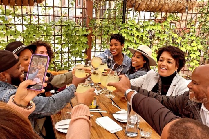 a group of people sitting and drinking wine