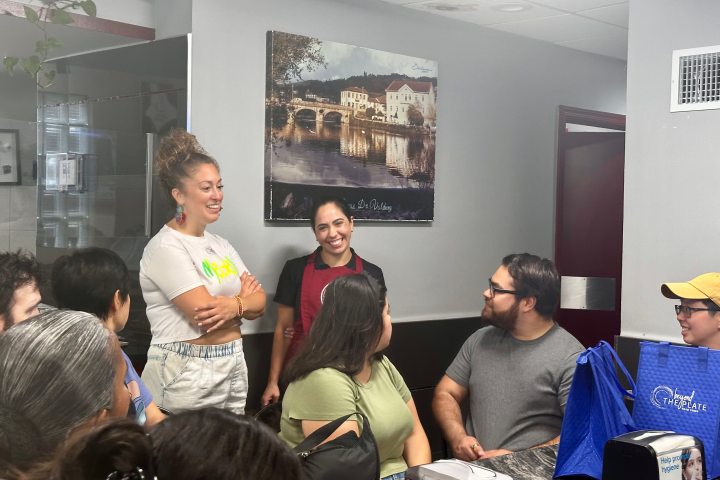 Group of people talking and smiling in a room with wall art.